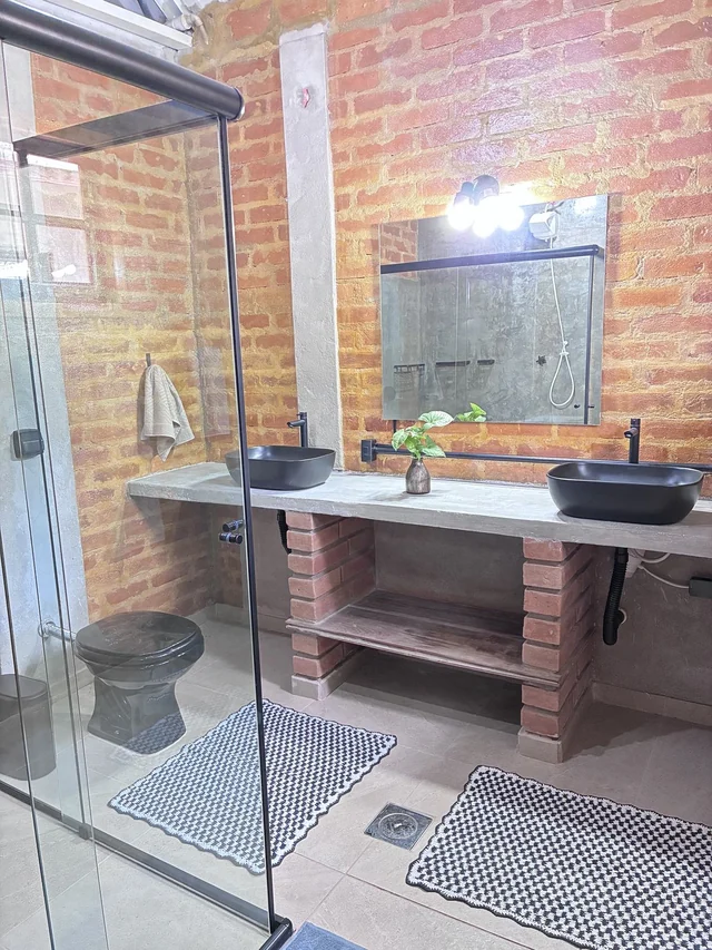 Banheiro com bancada e box de vidro
