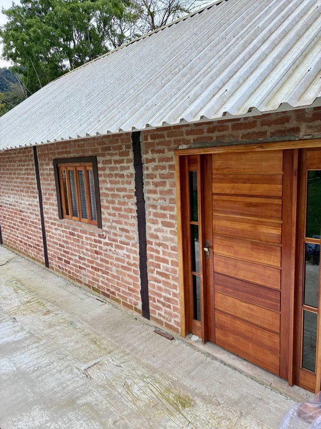Fachada real do Chalé Edmundo com tijolos e porta de madeira